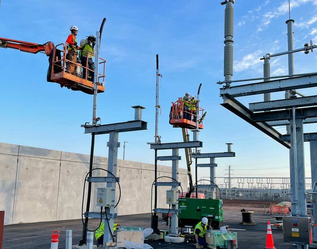People on scissor lifts working at a substation